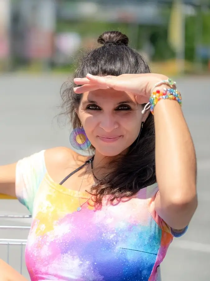 Martina Schatzl-Bachträgl im Profil-Nahaufnahme mit der linken Hand über den Augen, um diese vor der Sonne zu schützen. Sie sitzt dabei in einem Einkaufwagen.