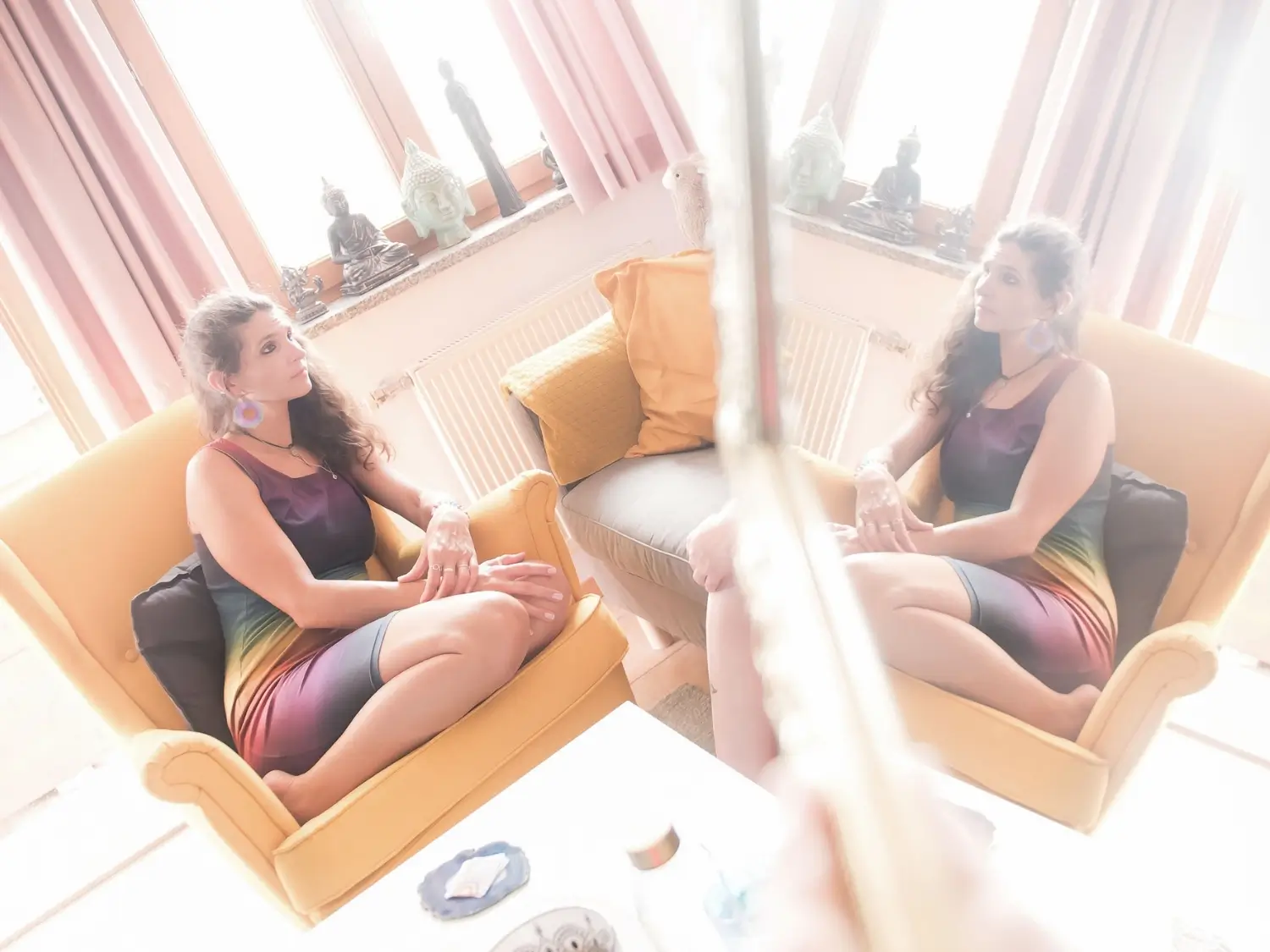 Martina sieht sich selbst im Spiegel während sie auf der Couch sitzt