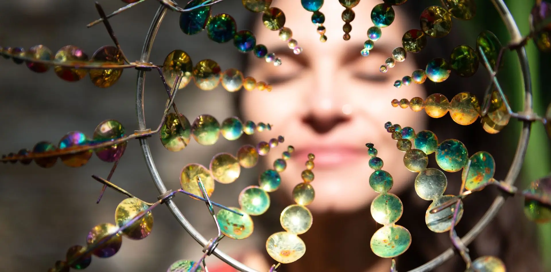 Frauengesicht hinter einem Kreis aus leuchtenden runden Elementen - Symbolbild für energetische Rückführungen